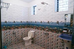 a bathroom with a toilet and a mosaic wall at Kumbaya Beachside Hostel & Apartments at Arambol Beach in Arambol