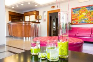 une table avec des verres et un vase dessus dans l'établissement Hotel Eco Del Mare, à Marina di Massa
