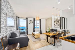 Una sala de estar con una mesa y un comedor. en "Rue Longue" Vue Mer, Spacieux, Rénové, en Menton