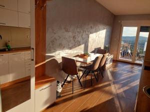 Apartmani DIVČI Tron 9 في ديفشيبار: مطبخ وغرفة طعام مع طاولة وكراسي
