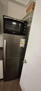 eine Mikrowelle auf einem Kühlschrank in einer Küche in der Unterkunft Hermoso departamento full equipado in Coquimbo