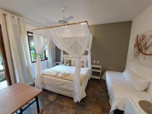 a bedroom with a bed with a canopy at Magias de Paraty Ecopousada in Paraty