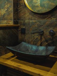 a bathroom with a stone sink and a mirror at De Smederij in Bolsward