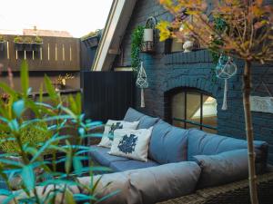 a blue couch sitting in front of a brick building at De Smederij in Bolsward