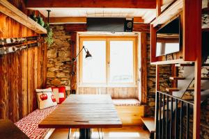 einen Holztisch in einem Zimmer mit Fenster in der Unterkunft Chalet des Amis by Lodji in Saint-Marcel