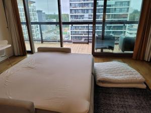 a large bed in a room with a large window at Modern apartment in Tapiola centre in Otnäs