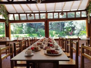 a long table with food on it in a room with windows at El Socavón in Guaranda