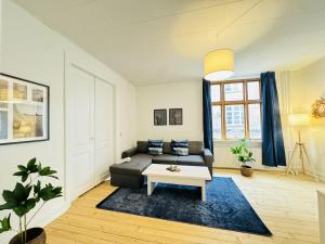 un soggiorno con un divano e un tavolo di aday - Beautiful 3 bedrooms apartment on Jomfru AneGade ad Aalborg