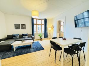 un soggiorno con un divano, un tavolo e delle sedie di aday - Beautiful 3 bedrooms apartment on Jomfru AneGade ad Aalborg Altre 19 foto