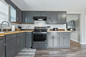 Una cocina con gabinetes grises y una estufa. en Holly House Cleveland, en Cleveland