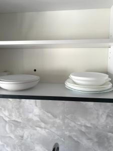 two images of a shelf with plates on it at CENTRAL ROOMS WITH GREAT VIEW shared bathroom no parking in Skopje +107 photos