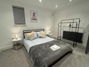 a bedroom with a bed with two tables and two lamps at Modern 3bed, Garden, Surbiton St in Surbiton +13 photos