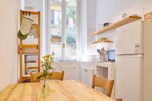 una cucina con tavolo in legno e vaso; di Classic Commenda - Porta Romana a Milano Altre 10 foto