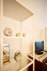 una stanza con orologi sugli scaffali e una TV di Classic Commenda - Porta Romana a Milano
