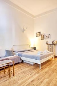 due letti in una stanza con pavimenti in legno di Classic Commenda - Porta Romana a Milano