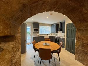 a kitchen and dining room with a table and chairs at HomeDecor Cottages - Old Stable House in Alnwick