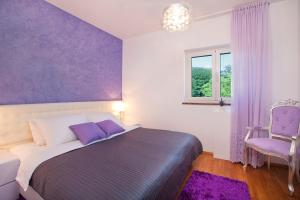 a bedroom with a bed and a purple wall at Villa Diora in Karojba +17 photos