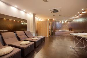 a salon with chairs and a bath room with a tub at Villa Diora in Karojba