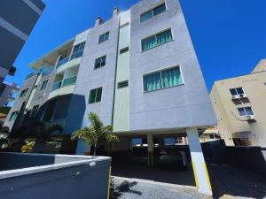 a tall gray building with green windows on it at Residencial Alianza - Depto de 1 habitacion 203 in Bombas +5 photos