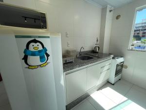 a refrigerator with a penguin sticker on it in a kitchen at Residencial Alianza - Depto de 1 habitacion 203 in Bombas