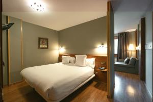 a hotel room with a bed and a couch at Aparthotel AnyosPark Mountain & Wellness Resort in Anyós
