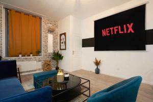 a living room with a netflix sign on the wall at Maison 4 chambres et jacuzzi pour 8 personnes in Roubaix