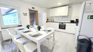 Una cocina blanca con una mesa y sillas blancas. en -CS24- Six rooms apartment with terrace - KP01, en Iserlohn