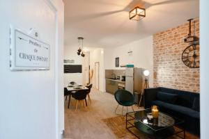 a living room with a couch and a table at Maison 4 chambres et jacuzzi pour 8 personnes in Roubaix