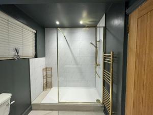a shower with a glass door in a bathroom at HomeDecor Cottages - Old Stable House in Alnwick +32 photos