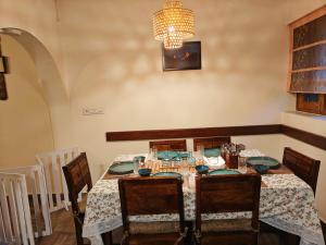 a dining room with a table and a chandelier at Woody Trails - Astronomy, Graphology, Family, Kainchi Dham in Bhowāli