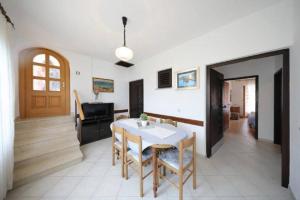 a dining room with a table and a piano at Knež - Relaxing Apartments Near the Sea on Mali Iž in Mali Iž
