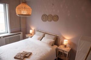 una camera da letto con un letto bianco con due luci sopra di Family house with sauna close to the sea a Ostenda