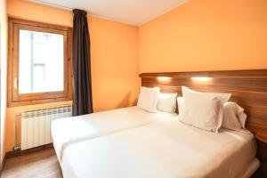 a bedroom with two beds and a window at Aparthotel AnyosPark Mountain & Wellness Resort in Anyós