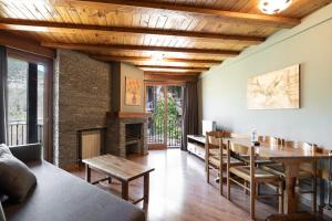 a living room with a table and a fireplace at Aparthotel AnyosPark Mountain & Wellness Resort in Anyós