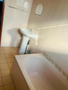 une salle de bain avec un lavabo et une baignoire dans l'établissement KwaMgozimba guest house 1 Room3 or 5, à Durban 19 autres photos