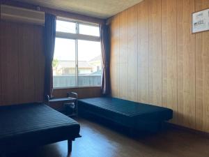 a room with two beds and a window at Oita City Vacation Condominium in Oita