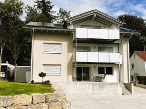 a white house with a stone wall in front of it at Ferienhaus DONAUzeit in Sigmaringen