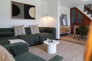 a living room with a couch and a table at Casa de Pedra by An Island Apart in Ribeira Brava