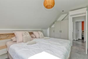 a bedroom with a large white bed with pink pillows at Villa Ker Minet - Houat - 8 pers in Piriac-sur-Mer +19 photos