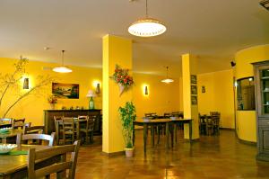 un restaurante con paredes amarillas, mesas y sillas en BiancaNeve B&B, en Capracotta