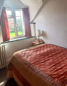ein Schlafzimmer mit großem Bett und Fenster in der Unterkunft 4 Bedroom Cottage in Wickwar, The Old Stables Guest House in Wickwar + 7 Fotos