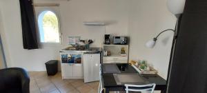 a kitchen with a white refrigerator and a table at 3 logements jusqu'à 11 personnes LE BARCARES plage et village de noel à pied in Le Barcarès