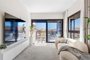 a living room with a couch and large windows at MEDANO4YOU Westside Penthouse in El Médano