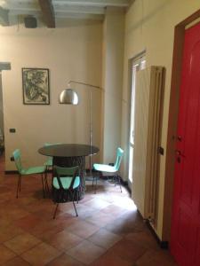 帕維亞的住宿－Mood-Siro Comi，配有桌椅和红色门的房间