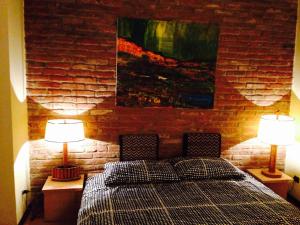 una camera con un letto con due lampade e una parete di mattoni di Mood-Siro Comi a Pavia