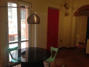 帕維亞的住宿－Mood-Siro Comi，一间设有玻璃桌和绿色椅子的用餐室