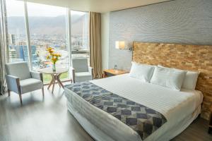 a hotel room with a bed and a table with chairs at Hotel Terrado Cavancha in Iquique +62 photos