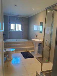 a bathroom with a toilet and a sink and a tub at Brix 7 single beds in Johannesburg