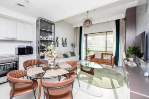a kitchen and living room with a glass table and chairs at Luxury apartments at Vida Residences in Dubai