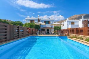 a swimming pool in front of a villa at Lindos Sapphire in Lindos